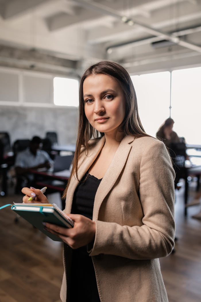 Professional woman holding notebook in a contemporary office. Ideal for corporate themes.